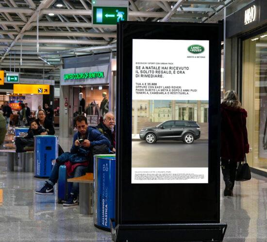 Schermo DOOH con Land Rover Discovery Sport Urban Pack in sala interna di aereoporto